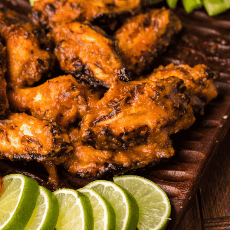 Golden, crispy Outback-style Kookaburra chicken wings served on a plate with dipping sauce and garnished with herbs.