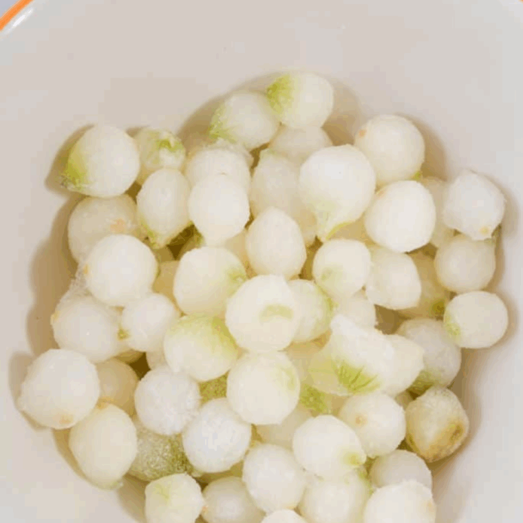 Place frozen pearl onions in a large mixing bowl.