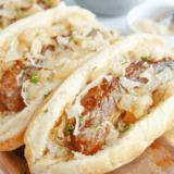 Air fried frozen brats in an air fryer basket, browned with blistered casings