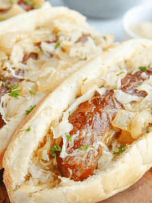 Air fried frozen brats in an air fryer basket, browned with blistered casings