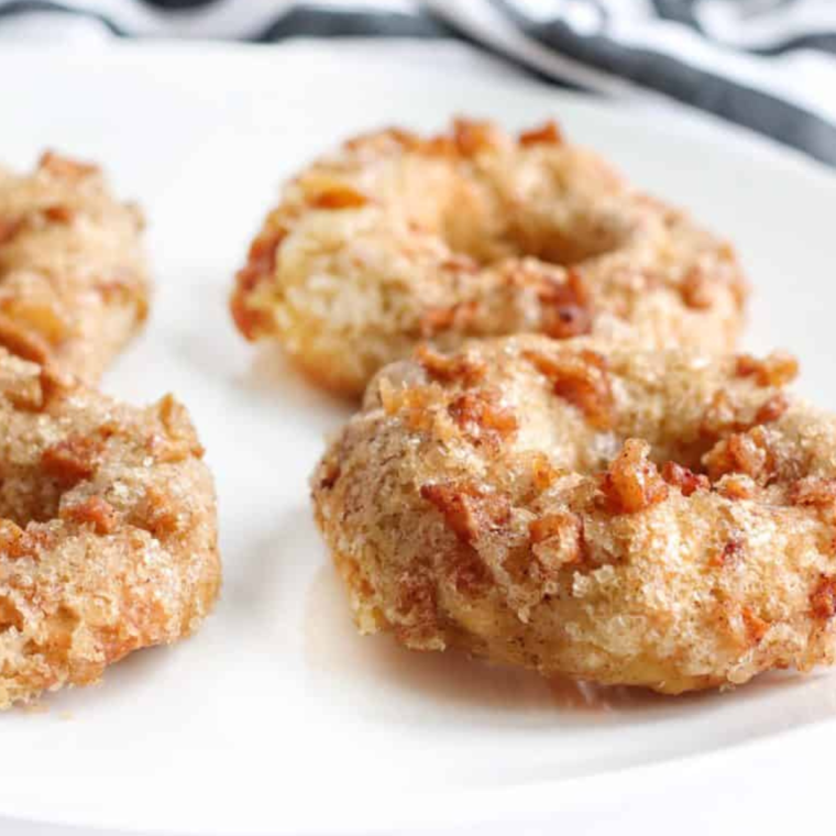 Freshly prepared apple cinnamon bagels in the air fryer tray, showcasing their pre-cooked appearance