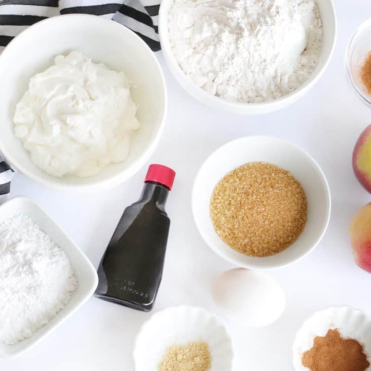 Key components for making apple cinnamon bagels: flour, yogurt, cinnamon, vanilla, apple pie spice, ginger, sugar, and fresh apples