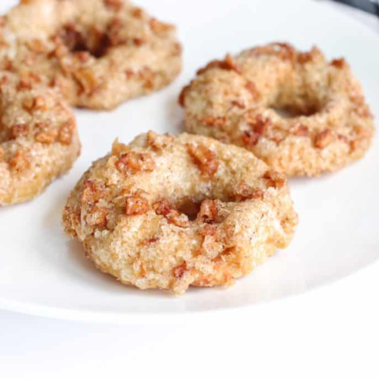 Air fryer tray filled with apple cinnamon bagels, ready to be air fried to perfection