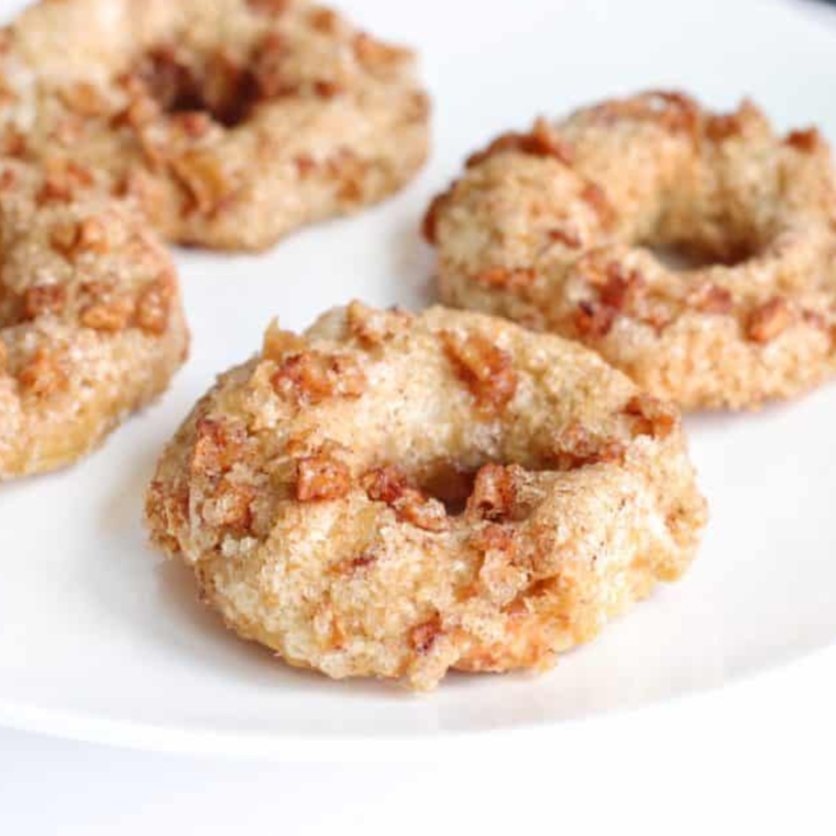 Freshly prepared apple cinnamon bagels in the air fryer tray, showcasing their pre-cooked appearance