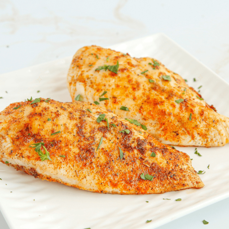 Juicy, perfectly cooked air fryer butterflied chicken breast served on a plate