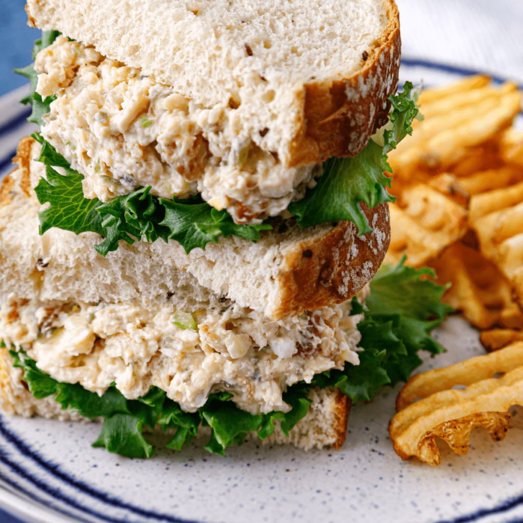 Freshly prepared Air Fryer Chick-Fil-A Chicken Salad being drizzled with dressing before serving.