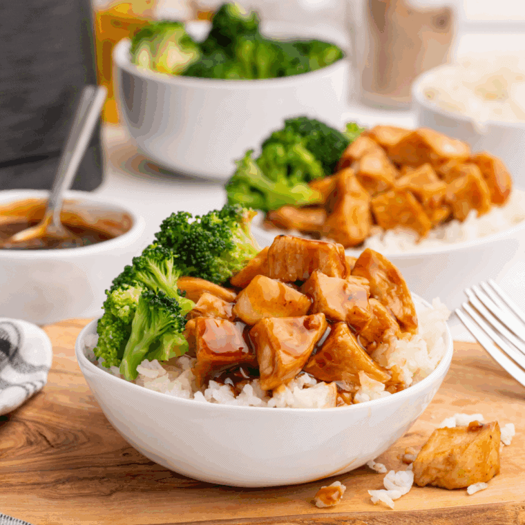 Bowl of air fryer teriyaki chicken served with rice, steamed broccoli, and colorful vegetables.