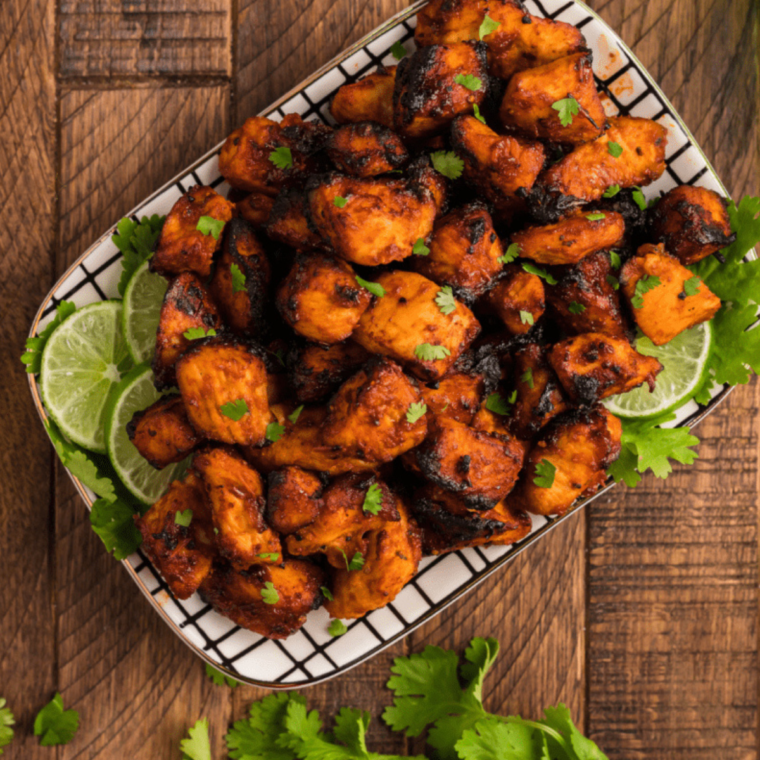 A plate of Air Fryer BBQ Chicken Bites, perfectly cooked with a crispy exterior and glistening BBQ sauce, ready to be served as a delicious appetizer.