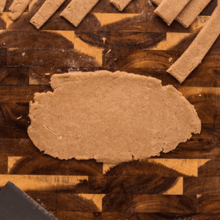 Rolling a tablespoon of dough into a thin log shape.