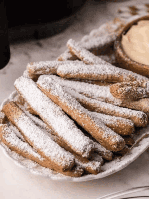 Air Fryer Funnel Cake Fries are a fun, crispy twist on the classic fair treat, made quickly and easily in your air fryer. These golden, crunchy fries are dusted with powdered sugar for the perfect sweet snack or dessert. With minimal oil and fast cooking, they’re a lighter and healthier way to enjoy funnel cake at home!
