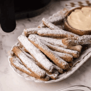 Air Fryer Funnel Cake Fries are a fun, crispy twist on the classic fair treat, made quickly and easily in your air fryer. These golden, crunchy fries are dusted with powdered sugar for the perfect sweet snack or dessert. With minimal oil and fast cooking, they’re a lighter and healthier way to enjoy funnel cake at home!