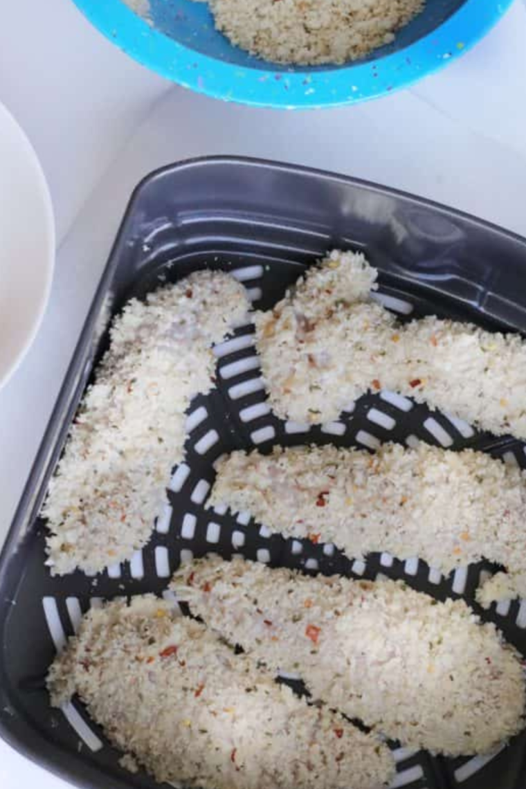 Place the coated chicken tenders into the air fryer basket.