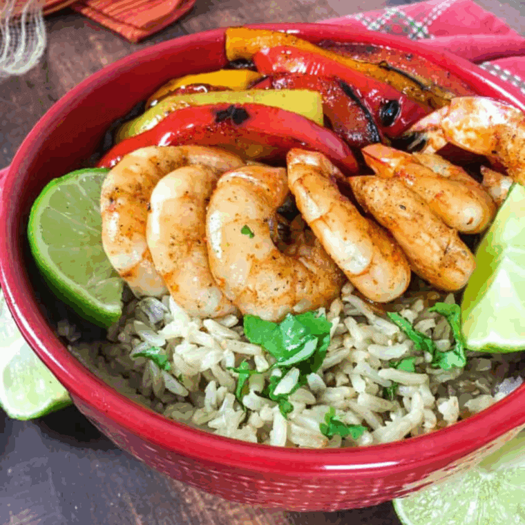 Air Fryer Shrimp Fajita Bowls with seasoned shrimp, bell peppers, onions, and rice topped with fresh herbs and lime.