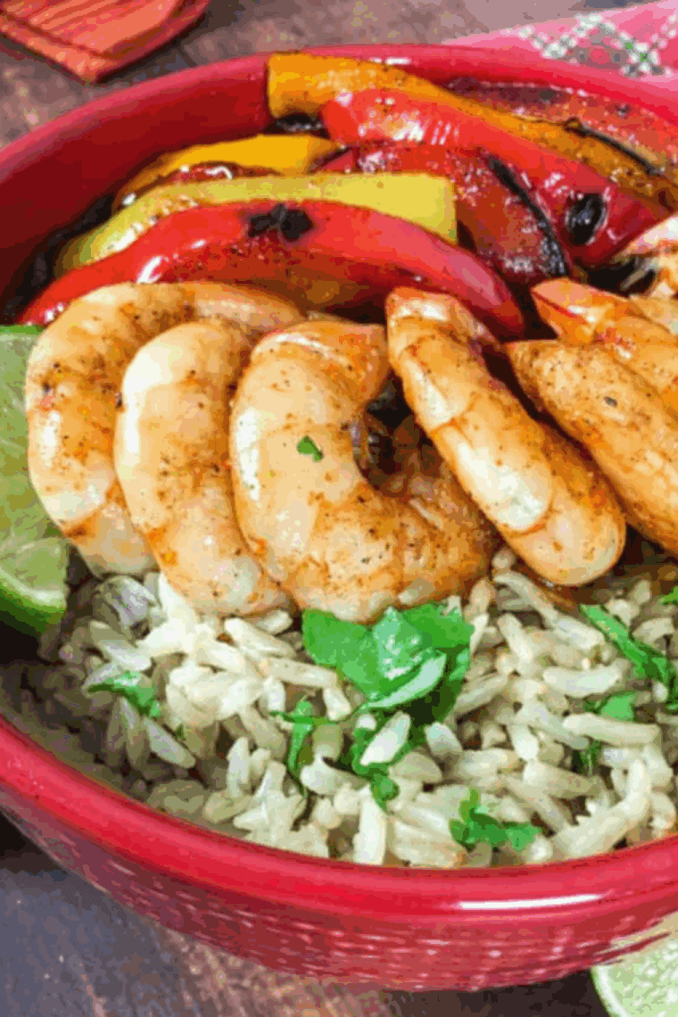 The best air fryer shrimp fajita bowls with seasoned shrimp, bell peppers, onions, rice, and fresh toppings in a colorful bowl.