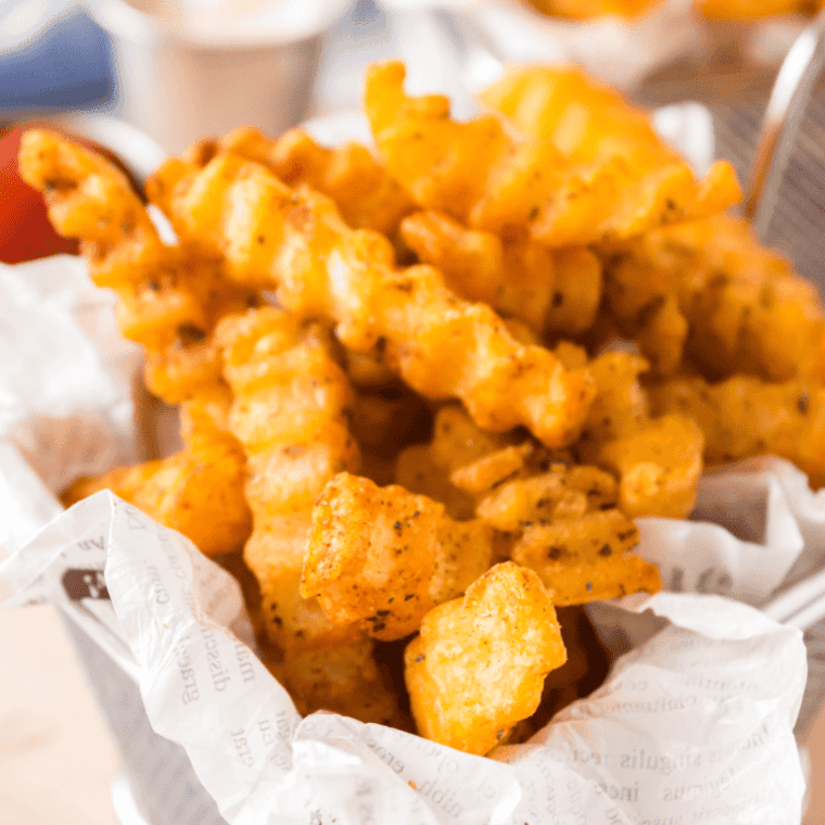 closeup: checkers frozen fries air fryer recipe in a basket with parchment paper