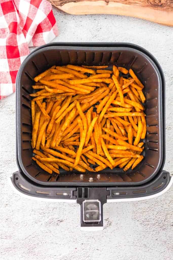 Overhead: checkers frozen fries in air fryer basket