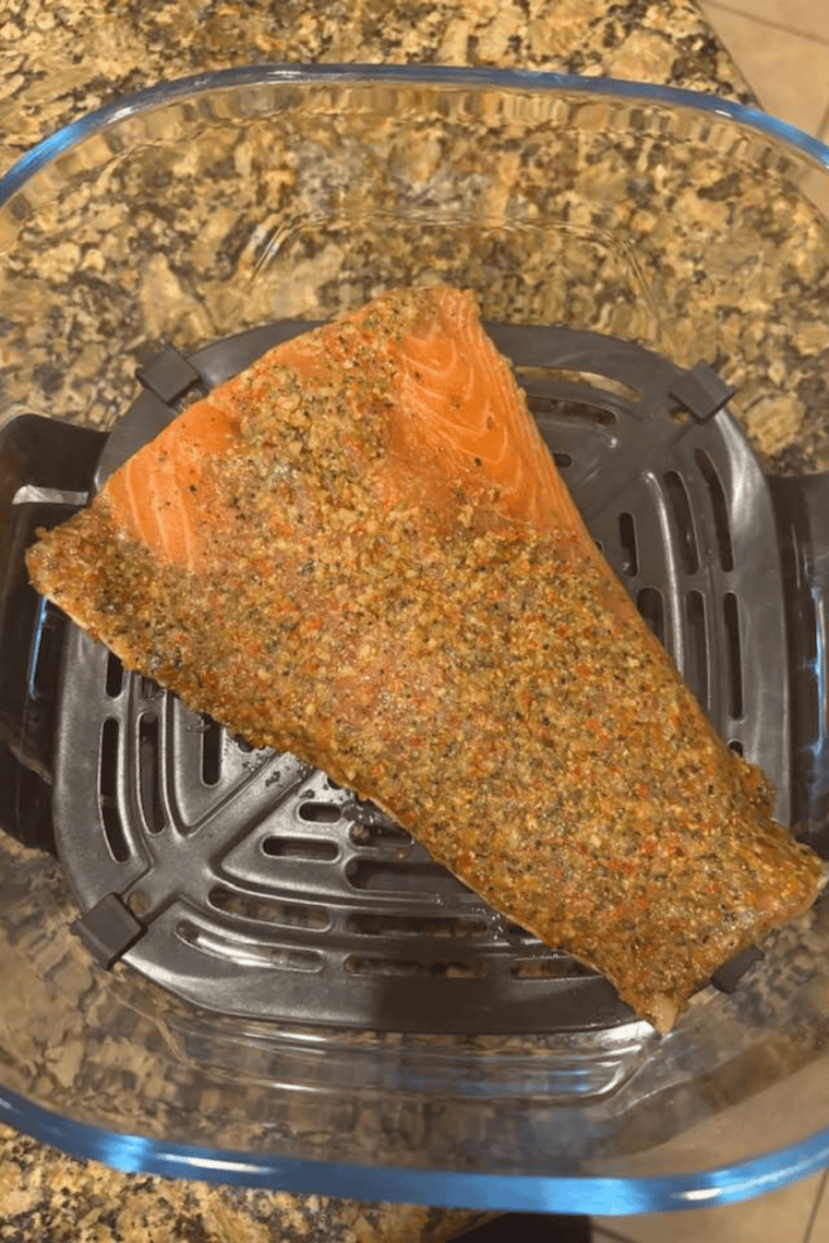 seasoned salmon fillets placed skin side down in Ninja CRISPI basket ready to cook