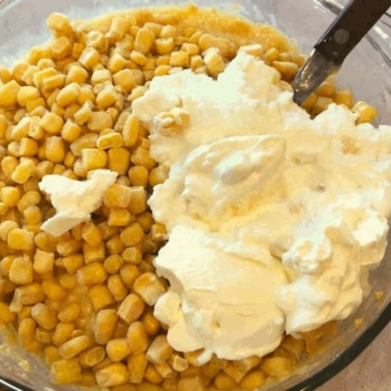 Adding sour cream to the cornbread mixture and stirring until well combined.