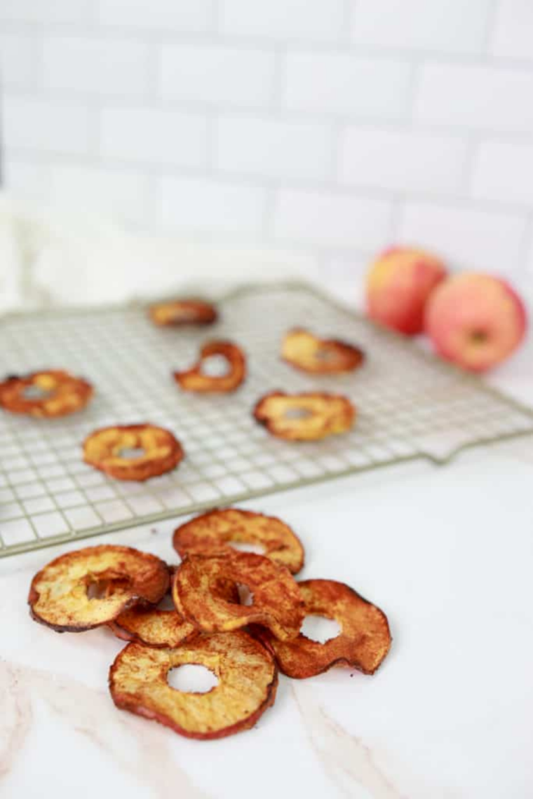 Golden crispy dehydrated apple chips close-up with cinnamon dusting