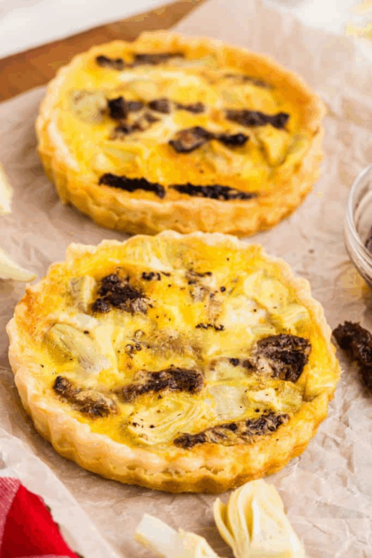 Golden slice of quiche reheated in air fryer basket with crispy crust
