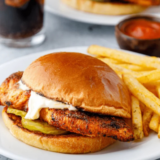 Air fryer blackened chicken breast sliced on a white plate, showing a dark spice crust and juicy interior