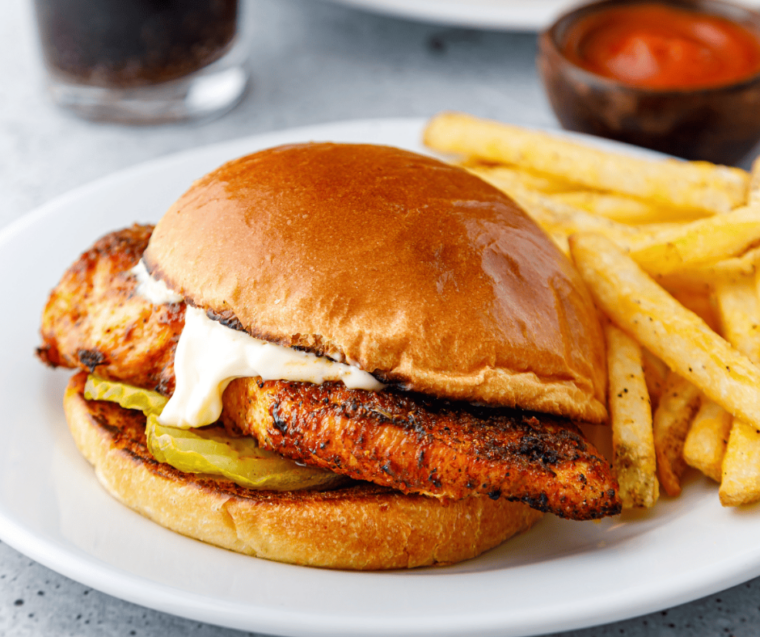 Blackened chicken sandwich on a brioche bun served with fries and a side of ranch