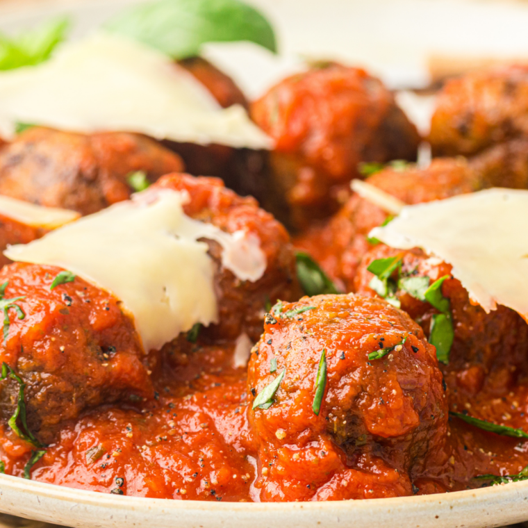 Air fryer chicken meatballs in marinara served over spaghetti on a white plate