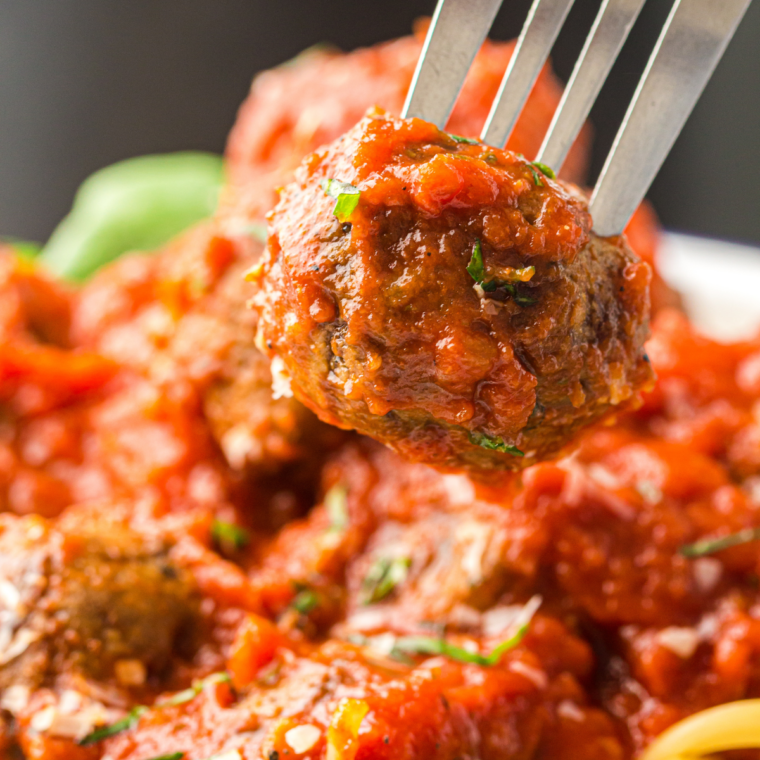 Chicken meatballs in marinara sauce plated with fresh parsley