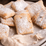 Copycat Marco's CinnaSquares piled on a white plate with vanilla icing for dipp