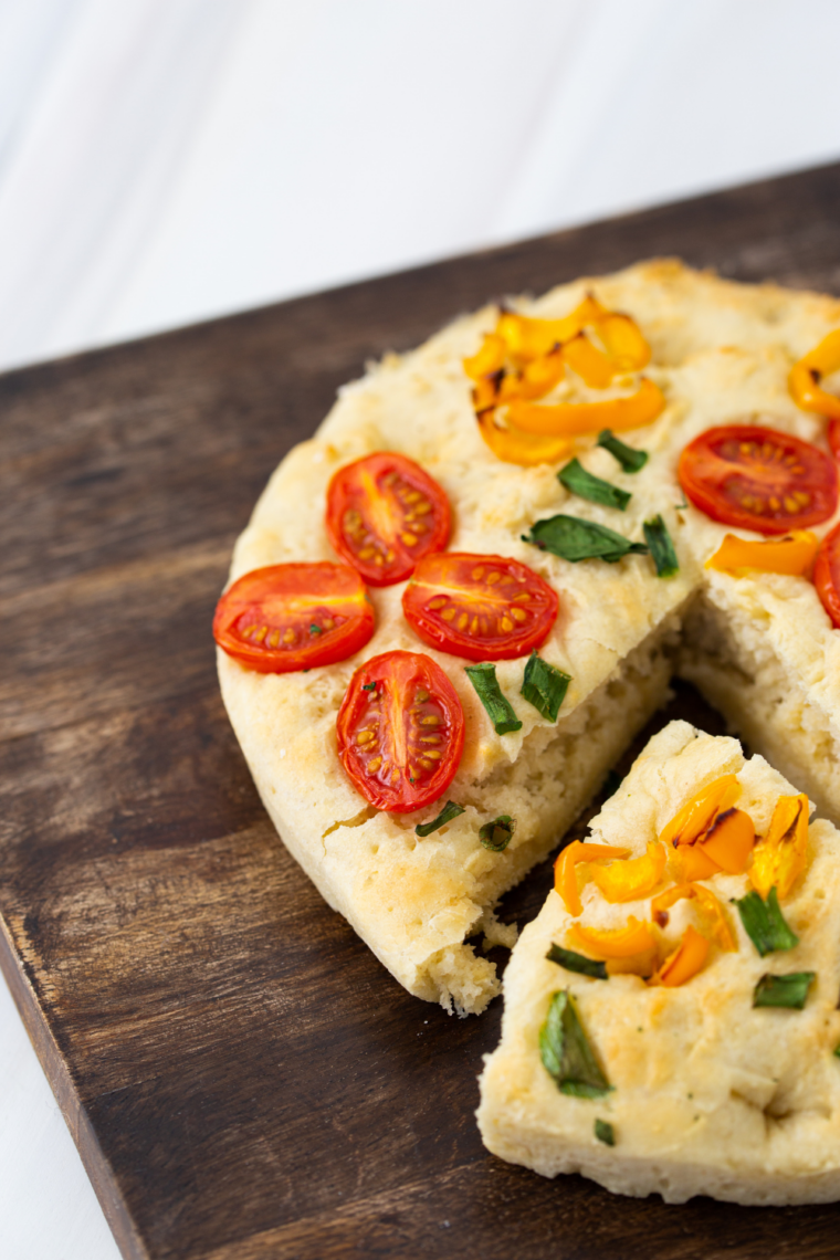 Air fryer garden focaccia with golden crust, fresh herbs, cherry tomatoes, and colorful vegetable toppings