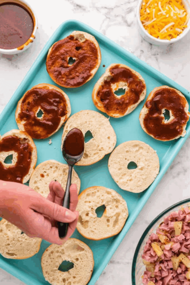 Spread Pizza sauce over the gluten-free bagels.