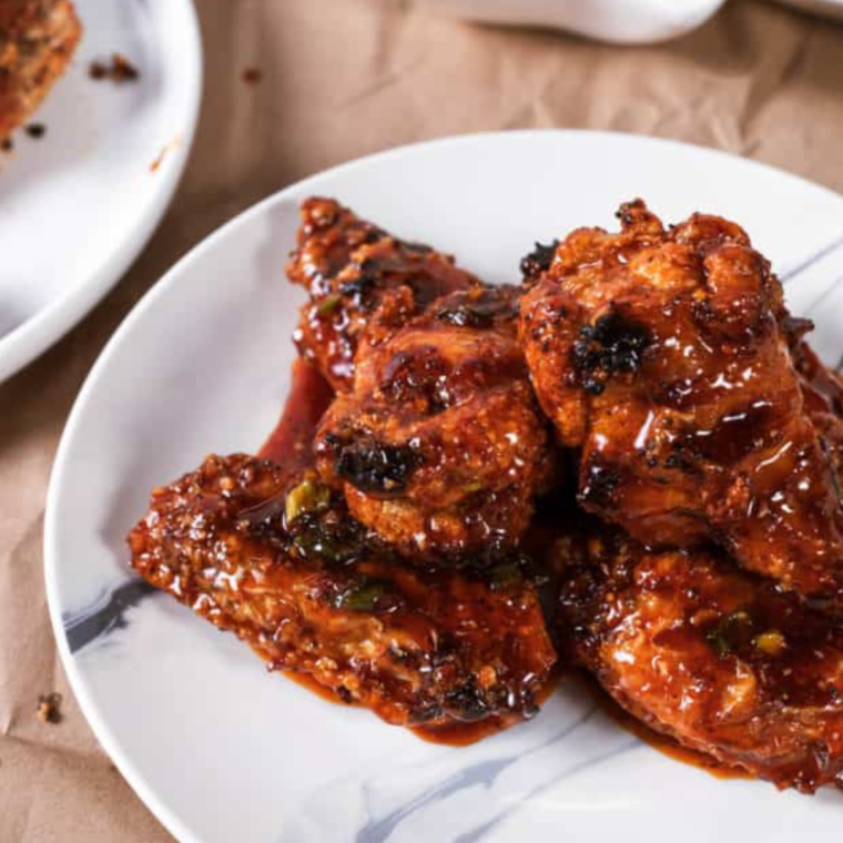 "Plate of Air Fryer Korean Chicken Wings garnished with sesame seeds and green onions"