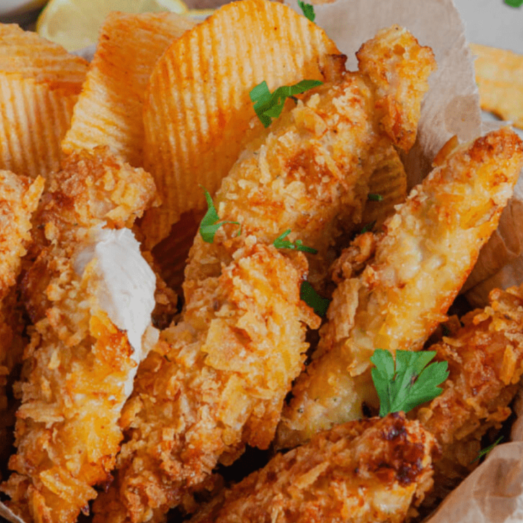 Air Fryer Potato Crusted Chicken with a crunchy, golden potato chip crust, served on a plate with a side of dipping sauce