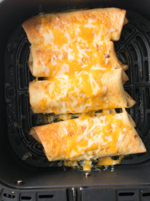 Crispy air fryer shrimp chimichangas cut open to show shrimp, rice, beans and melted cheese