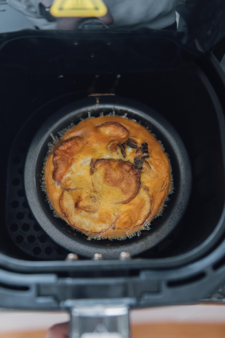 Golden-brown air fryer Spanish tortilla made with potatoes and eggs, garnished with fresh parsley on a plate.