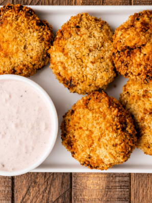 Creamy cranberry dip in a white bowl served next to golden fritters