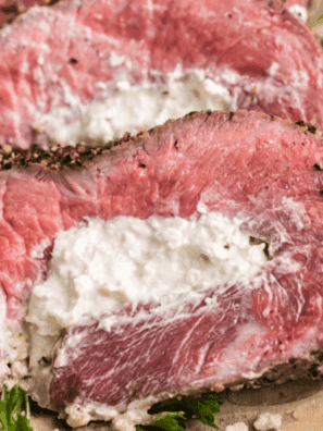 Sliced Black and Blue steak showing a dark, nearly black crust and a cool, bright red interior (blue-rare), served on a white plate.