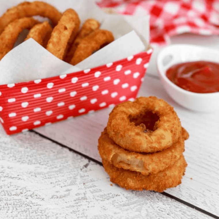 Golden and crispy Alexia Onion Rings cooked in an air fryer, served on a white plate with dipping sauce.