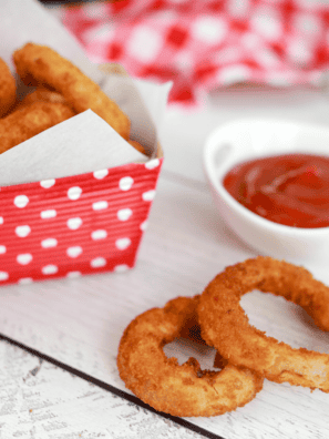 Crispy Alexia Onion Rings cooked to perfection in an air fryer, served on a plate with dipping sauce.