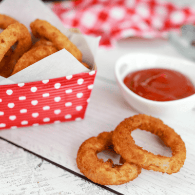 Crispy Alexia Onion Rings cooked to perfection in an air fryer, served on a plate with dipping sauce.