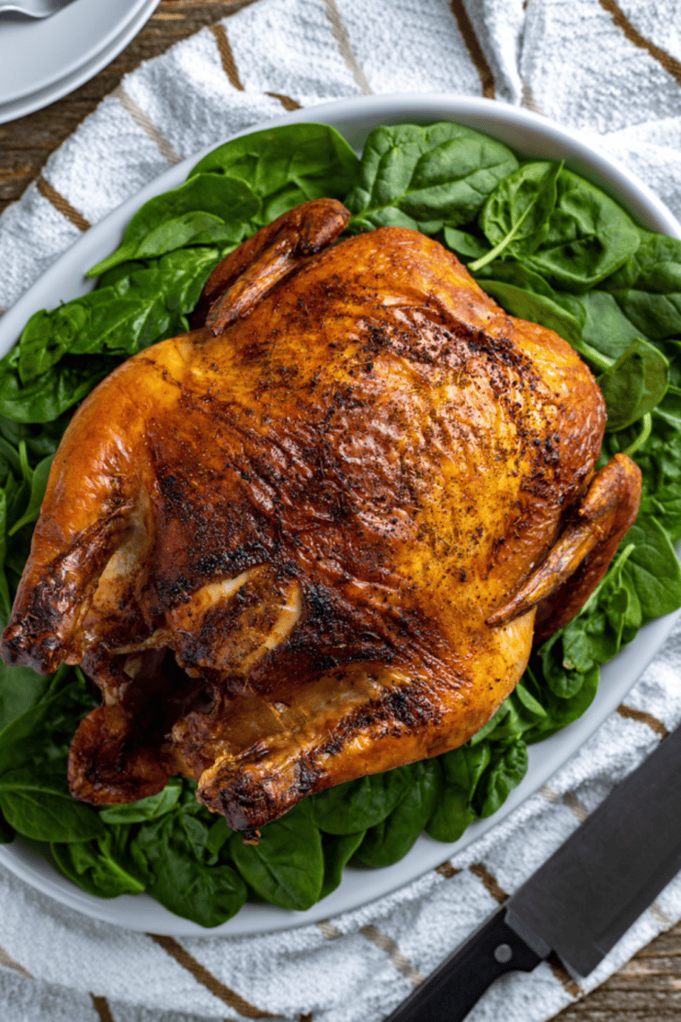 Whole roasted beer can chicken cooked in an air fryer with golden crispy skin and juicy meat inside.