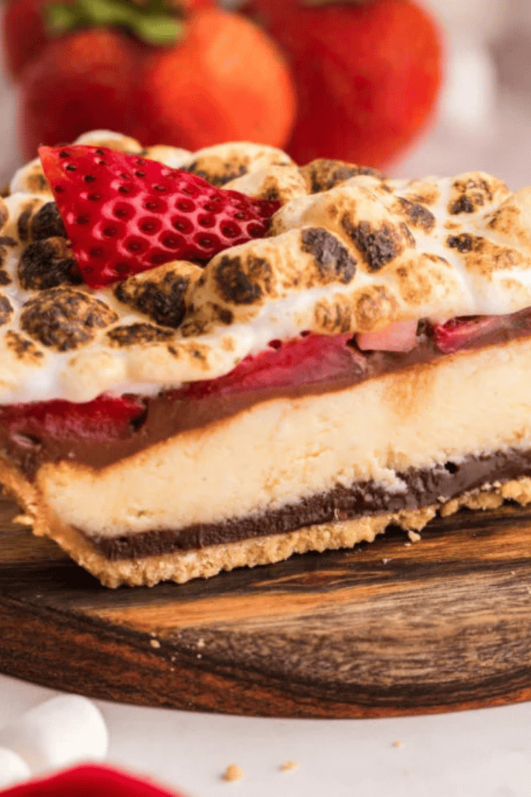 Air Fryer Berry S’mores Cheesecake topped with fresh strawberries, toasted marshmallows, and chocolate drizzle.