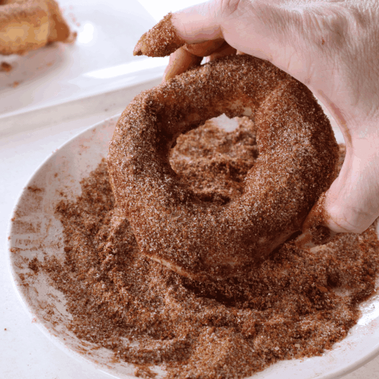 Air fryer caramel stuffed donuts with golden crust and caramel oozing from the center, dusted with sugar.