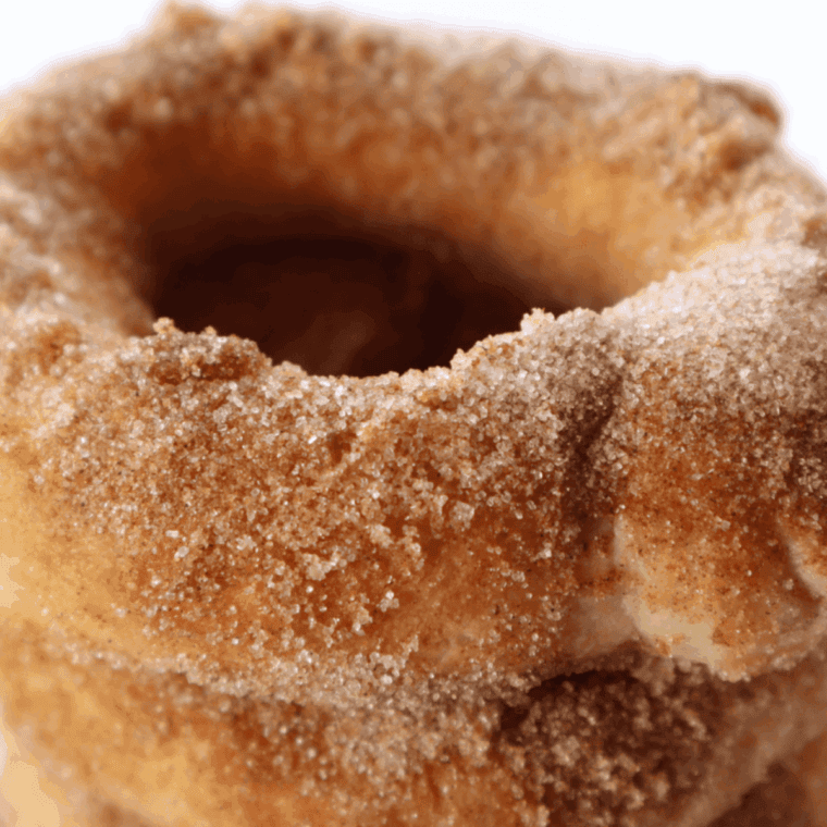 Close-up of air fryer caramel stuffed donuts with a golden crust and melted caramel oozing from the center.