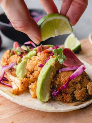 Crispy cauliflower tacos served with fresh veggies and lime on the side