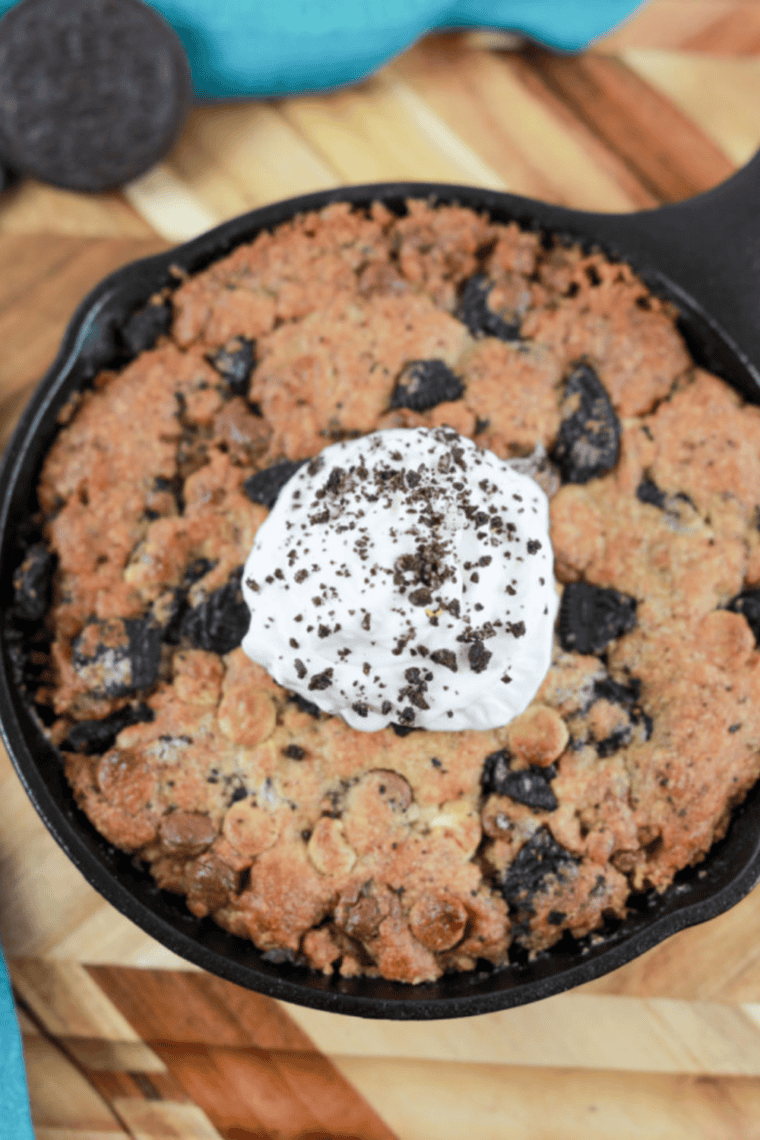 A golden air fryer cookies & cream pizzokie with a creamy Oreo center on a white plate, ready to serve.