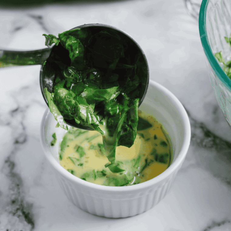 Mixing chopped spinach, oregano, basil, and mozzarella cheese into the egg mixture.