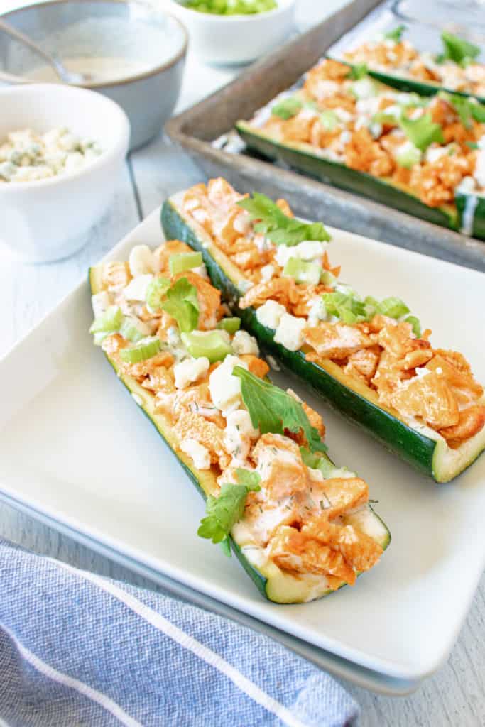 Can I make Buffalo Chicken Zucchini Boats in any air fryer?
Yes, you can make Buffalo Chicken Zucchini Boats in most air fryers. The cooking instructions may vary slightly depending on the specific model you are using, but the general principles remain the same.

What temperature should I set my air fryer to?
Preheat your air fryer to 400°F (200°C) for the best results. This temperature allows the zucchini boats to cook evenly and helps achieve a nice crispy texture.

Do I need to adjust the cooking time when using an air fryer?
Yes, cooking times may vary when using an air fryer compared to a traditional oven. It's recommended to start with a slightly shorter cooking time, around 10 minutes, and then check for doneness. Continue cooking in 2-3 minute increments if needed until the zucchini is tender.

Should I coat the zucchini boats with oil before air frying?
Yes, it's a good idea to lightly brush or spray the zucchini boats with olive oil before air frying. This helps add a bit of crispiness to the zucchini and prevents them from drying out.

Can I use frozen chicken for the filling?
It's best to use cooked and shredded chicken for the filling of Buffalo Chicken Zucchini Boats. If you're using frozen chicken, make sure to thaw and cook it thoroughly before shredding and mixing it with the buffalo sauce and other ingredients.

Can I use different sauces instead of buffalo sauce?
Yes, you can certainly experiment with different sauces to suit your taste preferences. Barbecue sauce, ranch dressing, or a combination of sauces can be used instead of buffalo sauce. Feel free to get creative and customize the flavor to your liking.

Can I make the zucchini boats ahead of time?
While it's best to enjoy the zucchini boats fresh, you can prepare the components ahead of time. Hollow out the zucchini and cook and shred the chicken in advance. When you're ready to serve, assemble the zucchini boats with the buffalo chicken mixture and cook them in the air fryer.

How do I store leftovers?
If you have any leftovers, store them in an airtight container in the refrigerator for up to 2-3 days. Reheat the zucchini boats in the air fryer at a lower temperature (around 350°F/175°C) for a few minutes until heated through.

Remember, cooking times and temperatures may vary based on your specific air fryer model, so always refer to the manufacturer's instructions for best results.