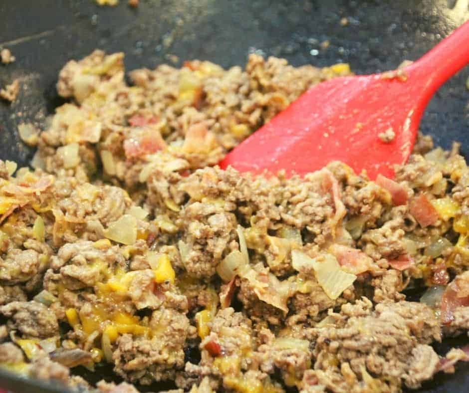 cooking cheeseburger eggrolls filling in a skillet