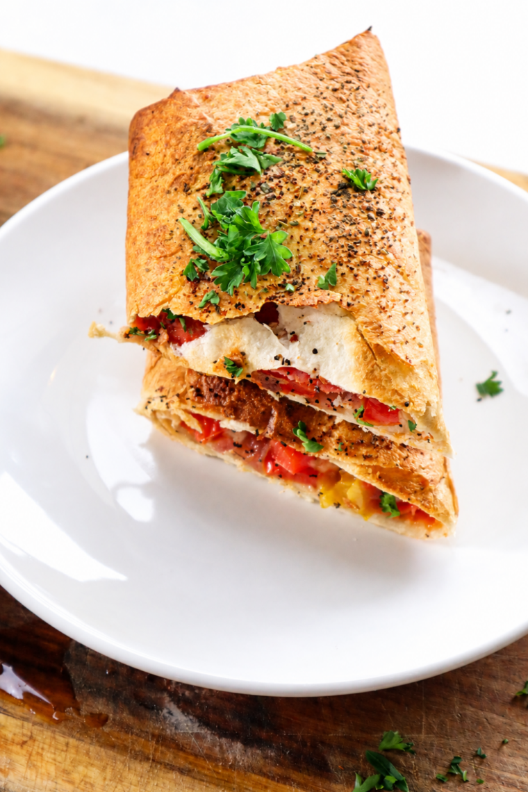 Golden air fryer turkey wraps stacked on a plate with marinara for dipping 